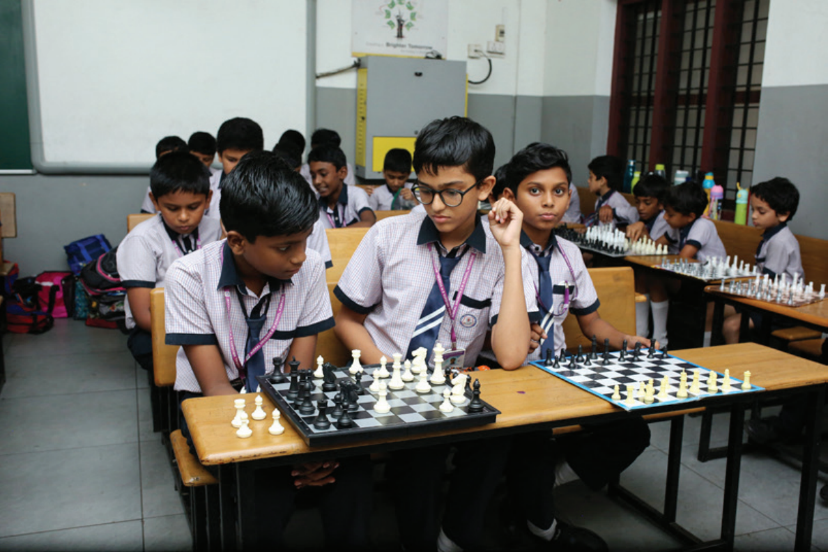 Students playing chess in a classroom